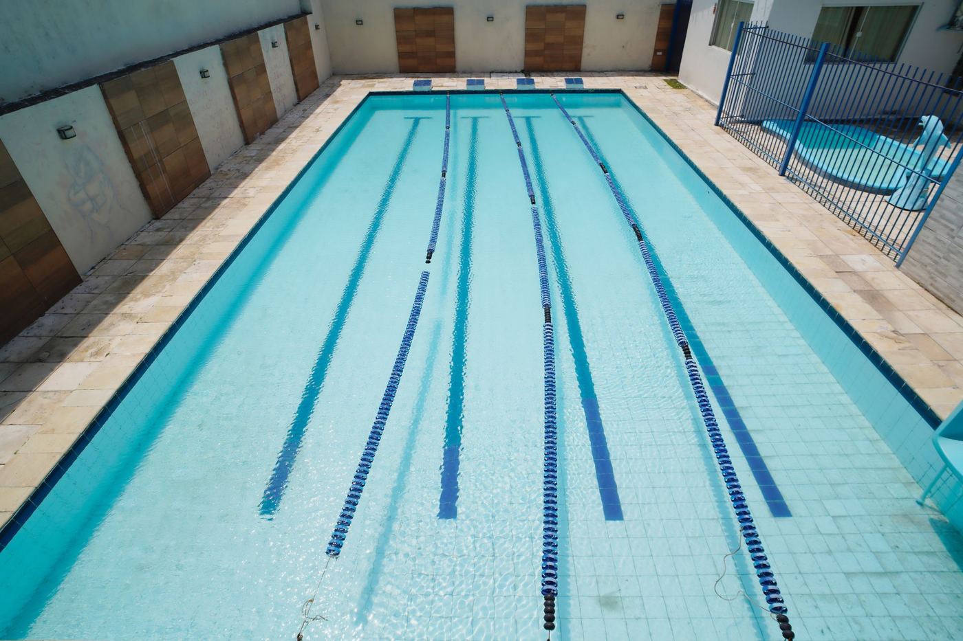 Piscina com raias vista de cima e, ao lado, a piscina infantil cercada
