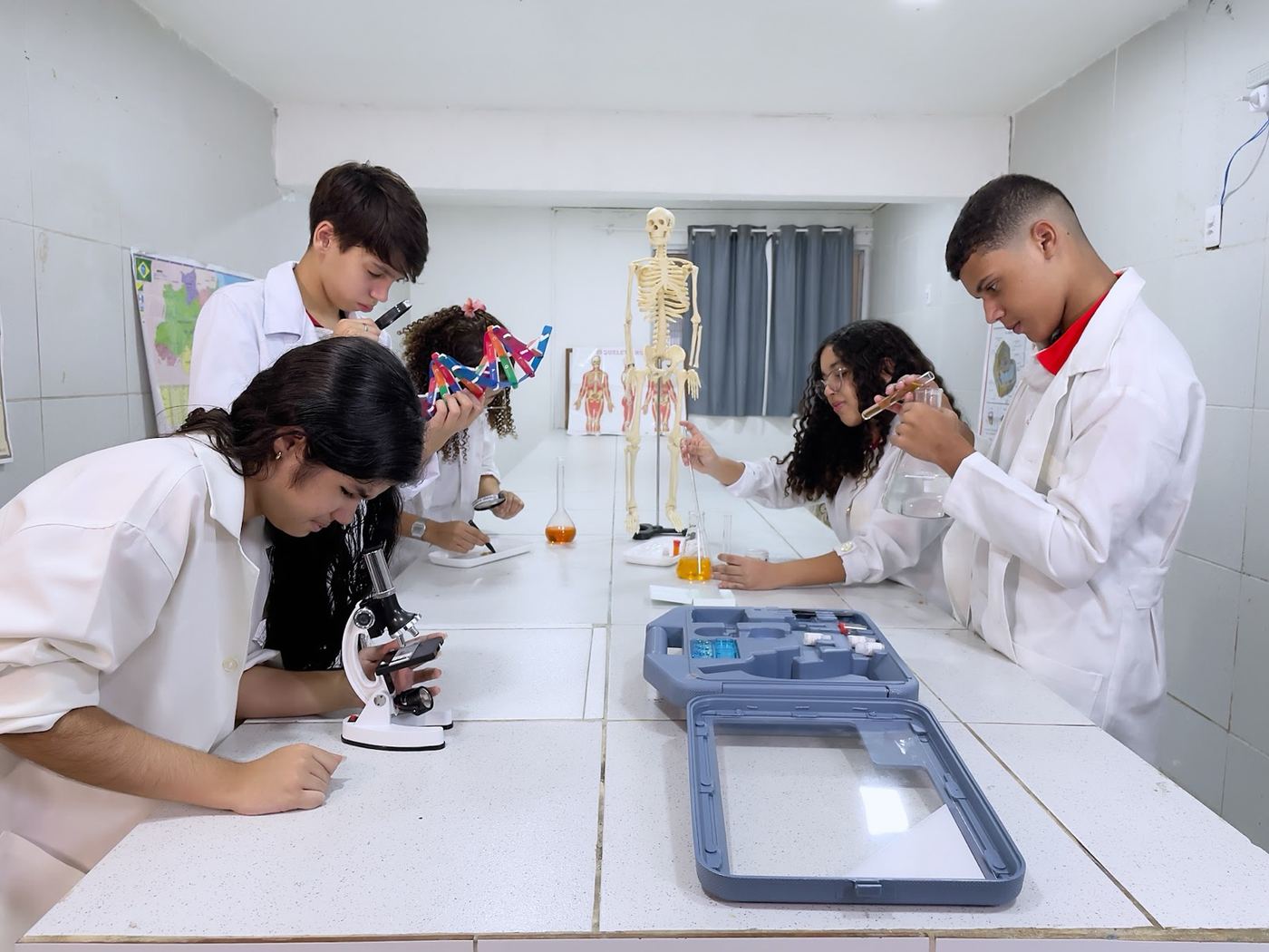 Estudantes de jaleco no laboratório de ciências do CMJ